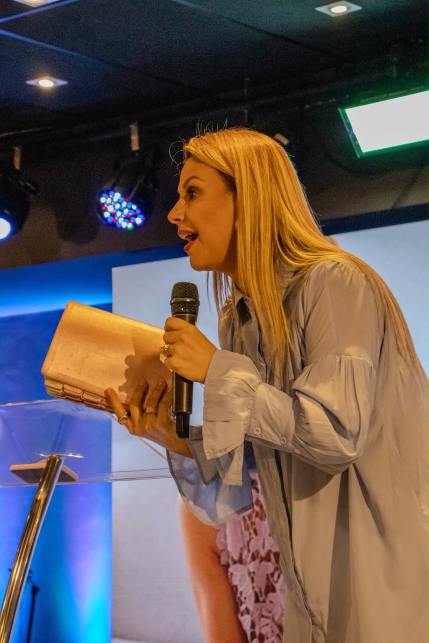 Mariana Simionato pregando com a Bíblia e o microfone